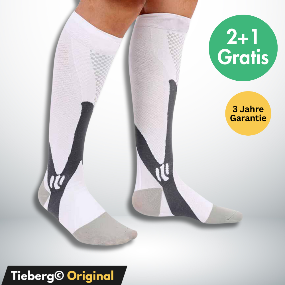 Ein Paar weißer und grauer Tieberg™️ Spezial Kompressionsstrümpfe mit schwarzen Akzenten ist auf den Unterschenkeln abgebildet. Textblasen sagen "2+1 Gratis" und "3 Jahre Garantie". Unterer Text: "Tieberg© Original".